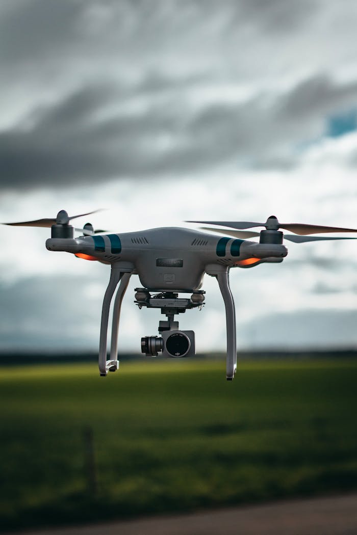 gallery-03 A drone flying over a green field under a dramatic cloudy sky, showcasing technology in nature.