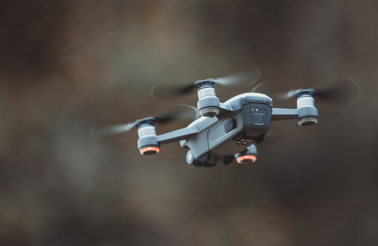 journey-01 A detailed close-up of a drone flying in an outdoor setting, showcasing its design and technology.