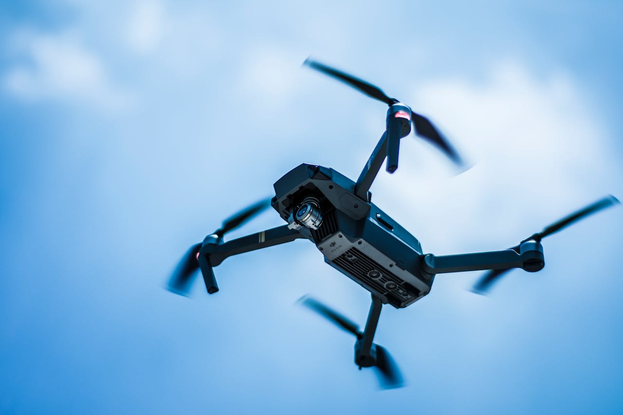 journey-02 A sleek drone captures the sky in action with a clear blue background, showcasing modern technology.