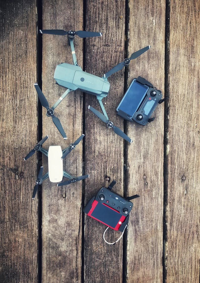 gallery-02 Aerial equipment and controllers displayed on a wooden backdrop, showcasing modern drone technology.